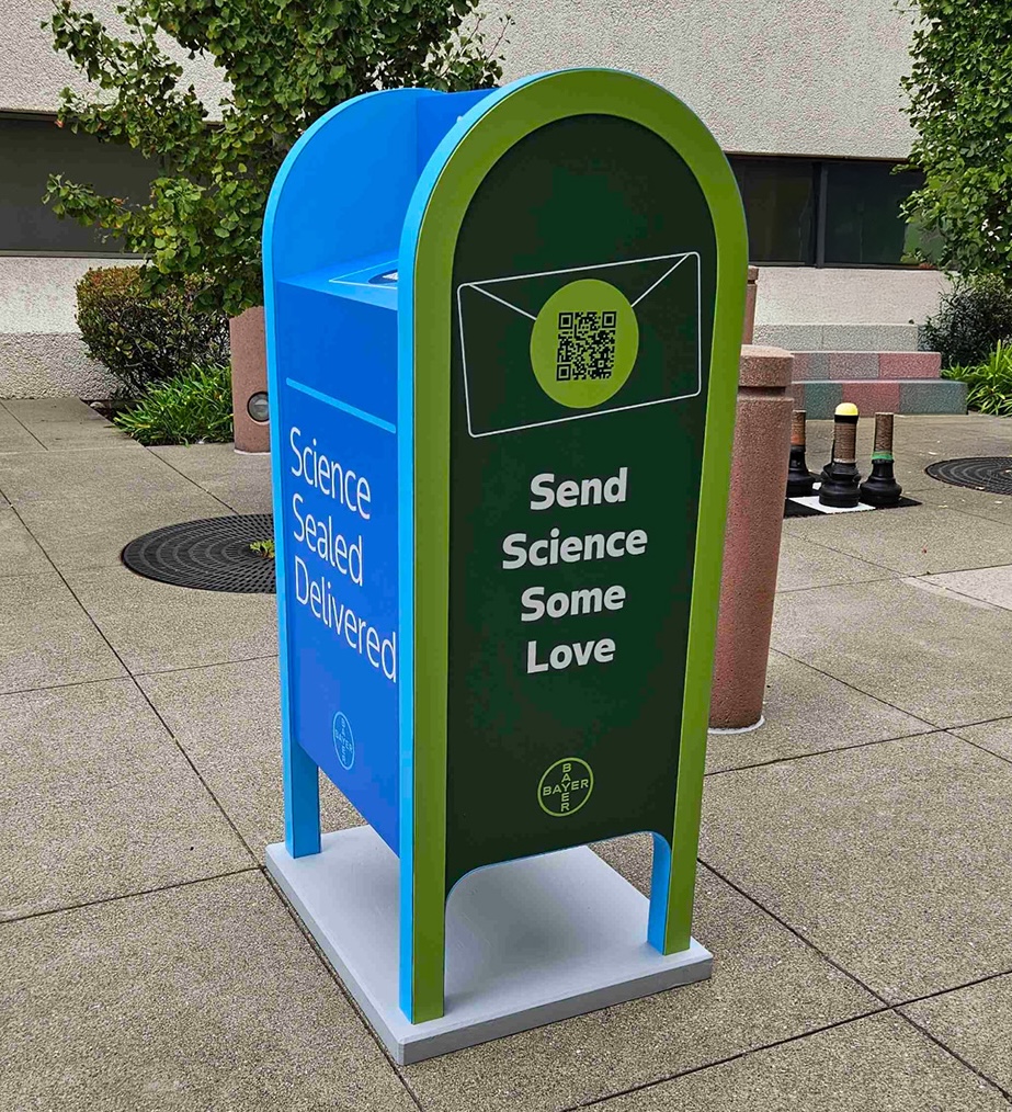Science Sealed Delivered mailbox - a blue and green branded mailbox with QR code saying 'Send Science Some Love'